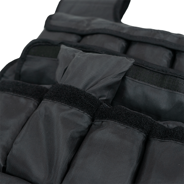 Gros plan sur les poches de poids réglables du gilet lesté noir de 20 kg de Matchu Sports, avec une poche à moitié sortie pour montrer comment cela fonctionne.